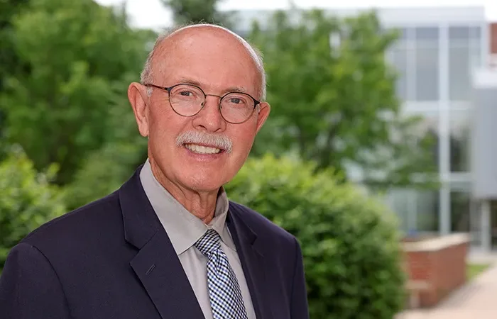 Interim Chancellor Charlie Bicak stands outside Warner Hall