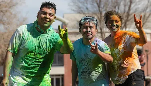 students covered in vibrant chalk at a holi event